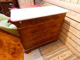 une commode en bois avec un plateau blanc dans une pièce
