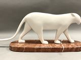 a white statue of a cat on a marble base