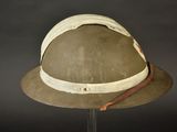 an old helmet with a leather band is on a stand