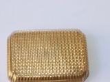a gold box that is sitting on a white surface
