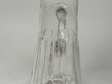 a clear glass vase with a silver handle on a white surface
