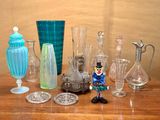 de nombreux vases en verre et autres objets en verre sur la table