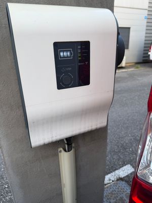 une voiture rouge garée à côté d'une borne de recharge électrique dans la rue