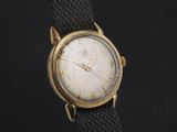 une photo d'une montre en or avec un bracelet noir