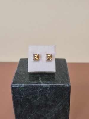 une paire de boucles d'oreilles posée sur un bloc de marbre