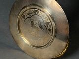 a gold plate with a bird on top of it