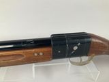 a close up of a shotgun with a wooden handle