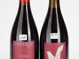 deux bouteilles de vin rouge posées l'une à côté de l'autre sur une surface blanche