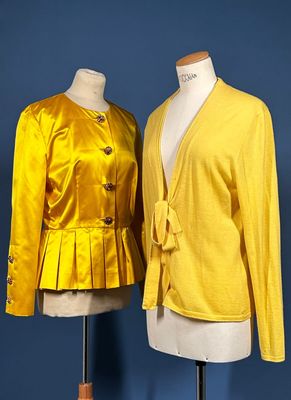 two mannequins dressed in yellow jackets and skirts on a mannequin stand