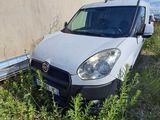 une camionnette blanche garée à côté d'un immeuble, dans un espace vert