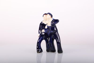a small figurine of a man sitting on a chair