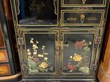a black and gold cabinet with flowers on it