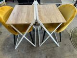 two yellow chairs and a table with a wooden table top