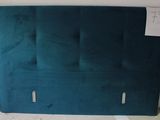 a picture of a bed with a blue headboard in a room