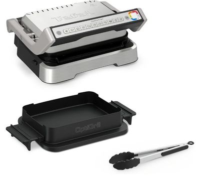 an image of a black and silver grill with a pan and tongs