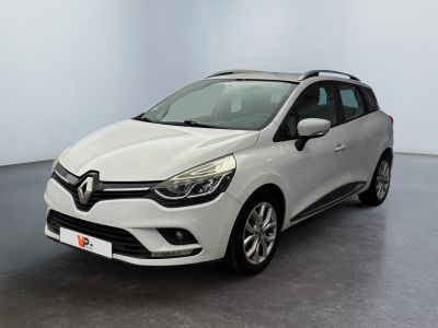 a white car is parked in a room with a black floor