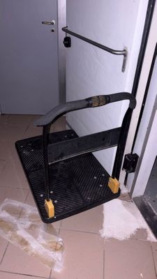 un tabouret noir dans un coin de la salle de bains