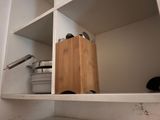 shelves with pots and pans on them in a white kitchen
