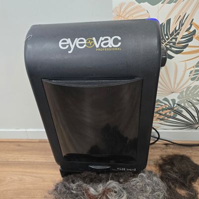 a hair dryer sitting on the floor next to a pile of hair