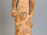 une statue représentant une femme tenant un chien sur un rocher