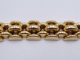 a close up of a gold chain bracelet on a white surface