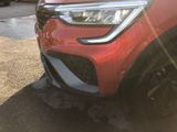 a close up of a red car parked in a parking lot