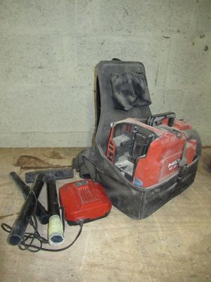 une image représentant une tronçonneuse à essence rouge et noire ainsi que d'autres outils