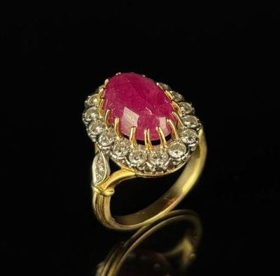 a close up of a pink stone and diamond ring on a black surface