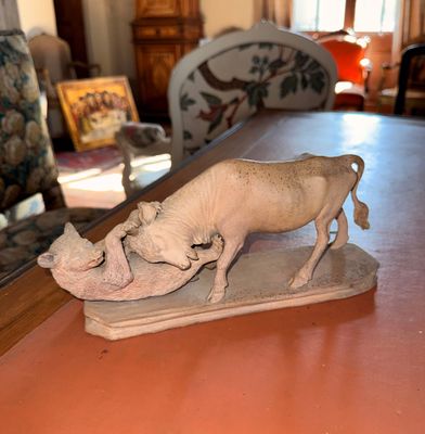 une figurine représentant une vache posée sur une table, avec un miroir en arrière-plan