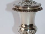 a silver urn with a cross on top of it