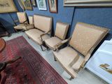 four chairs and a table in a room with pictures on the wall
