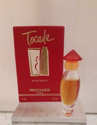 un flacon de parfum posé sur une table à côté d'une boîte
