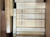many books in a cardboard box on the floor