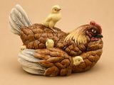 une figurine représentant une poule avec ses poussins
