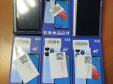 Plusieurs téléphones portables sont posés sur une table, avec une étiquette de prix accrochée dessus.