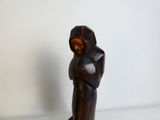une statue en bois représentant une personne portant une capuche