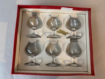 six wine glasses in a red box on a table