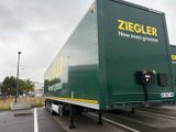un gros camion vert garé sur un parking