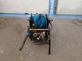 a blue hose sitting on top of a cart in a parking lot