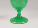 pair of green glass goblets with gold rims on a white surface