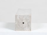 concrete block with hole in middle sitting on white surface