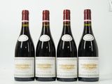 quatre bouteilles de vin sont alignées sur une surface blanche