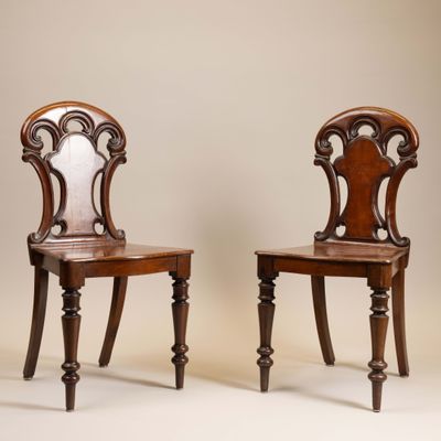 deux chaises en bois avec un dossier et des pieds sculptés, l'une avec une assise sculptée et l'autre avec un dossier sculpté