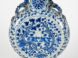 vase en porcelaine bleue et blanche orné d'anses en forme de dragon sur fond blanc