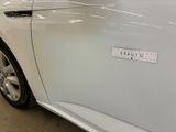a white car with a sticker on the side of it ' s door