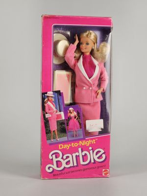 the barbie doll is in a pink box on a white surface
