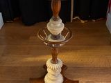 a table with a lamp on top of it on a hard wood floor