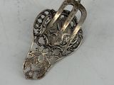 a silver spoon with a handle on a white surface