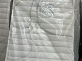 many mattresses stacked on top of each other in a warehouse