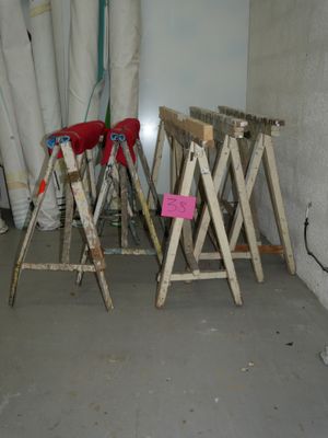 trois tabourets pliants en bois dans une pièce, avec un mur en arrière-plan